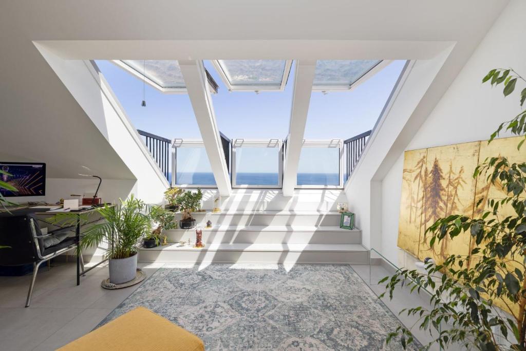 an attic hallway with a skylight and plants at BlueSunset Penthouse in Manilva
