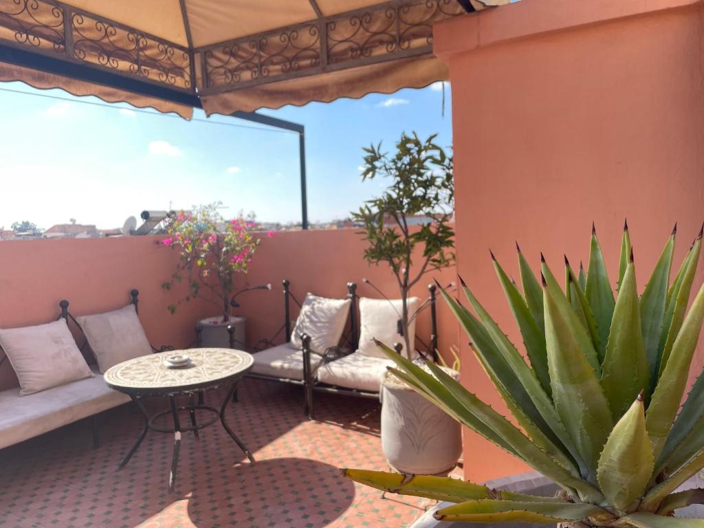 een patio met een tafel en een bank op een balkon bij Dar Dadès in Marrakesh