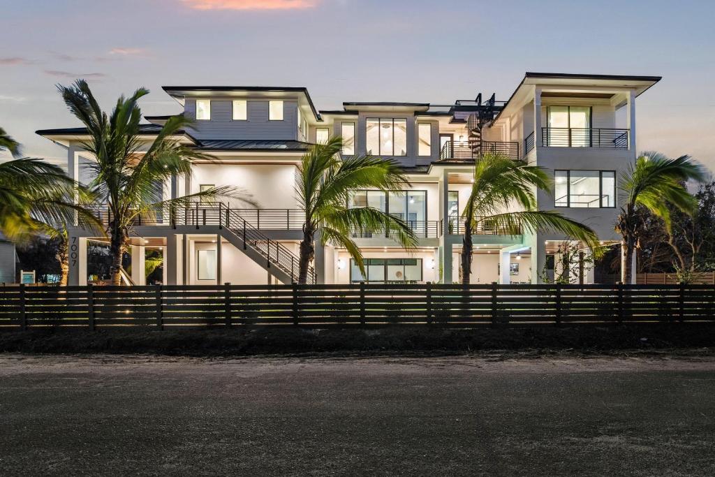 a large white house with palm trees in front of it at Point of Paradise - 7007 in Sarasota