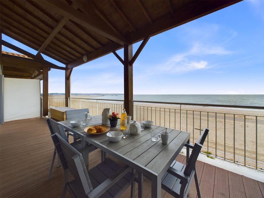 une table sur un balcon avec vue sur la plage dans l'établissement Sur la plage, appartement avec terrasse et vue mer, à La Tranche-sur-Mer