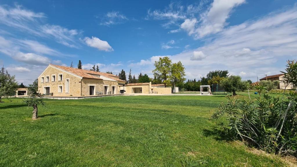 un grand jardin avec une maison et un terrain de football dans l'établissement MAGNIFIQUE Mas, à Orange