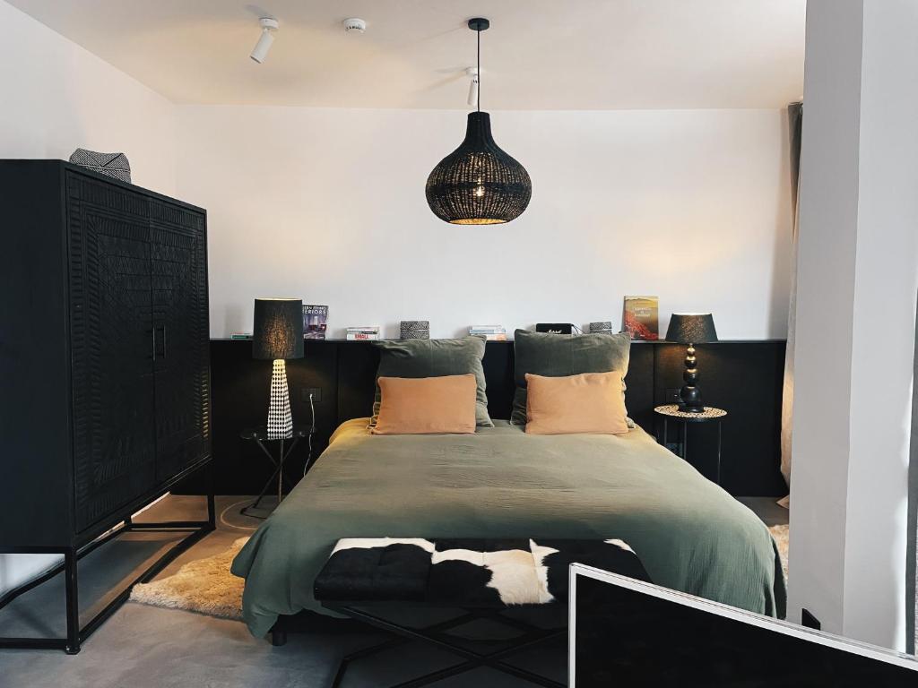 1 dormitorio con 1 cama grande y luz colgante en Black Mura, en Bansko