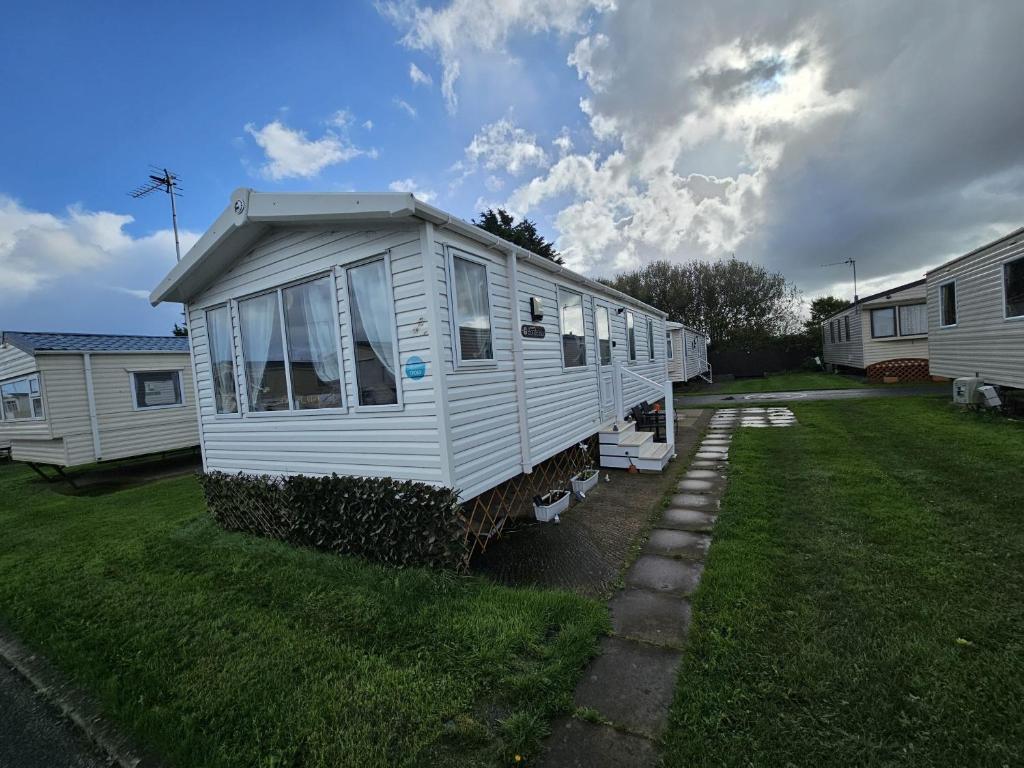 a white tiny house parked in a yard at Heidi 2 Bed Robin hood in Rhyl