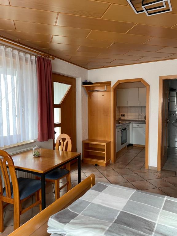 a living room with a dining room table and a kitchen at Ferienwohnung im Herzen Schönach in Herdwangen-Schönach