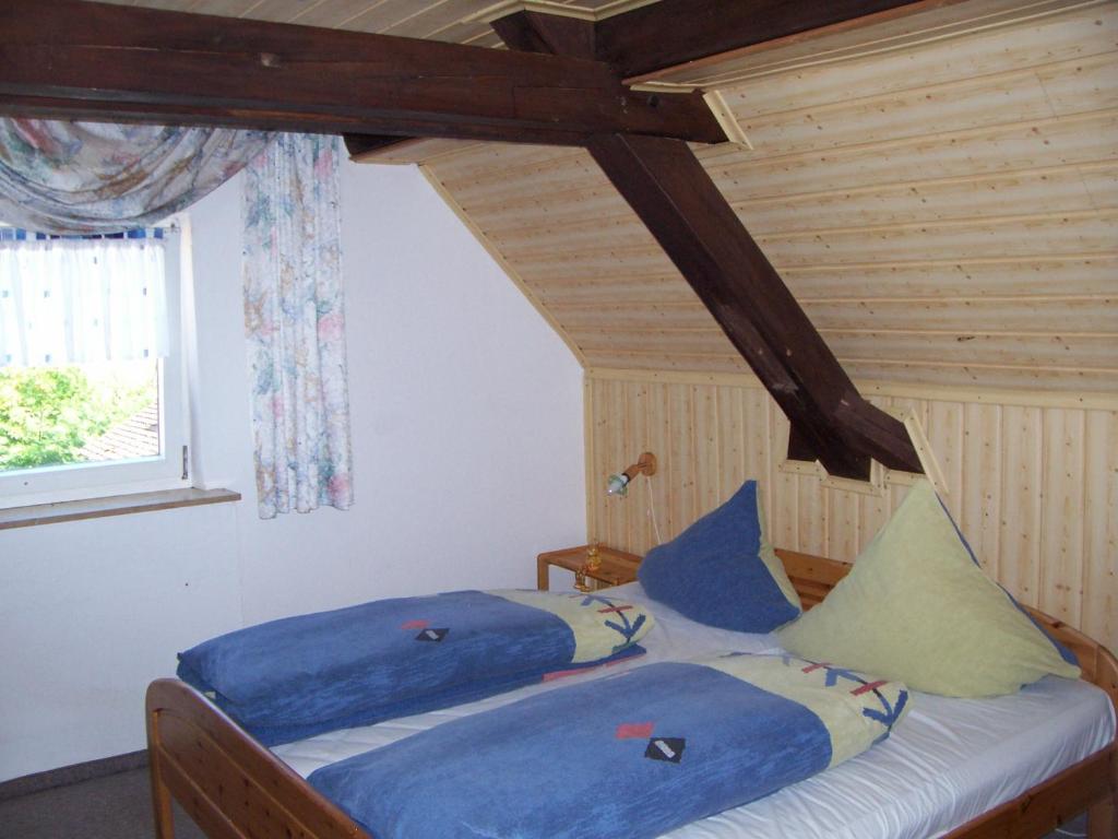 a bedroom with two beds with blue sheets and a window at Landgasthof Gotzenmühle in Lichtenau