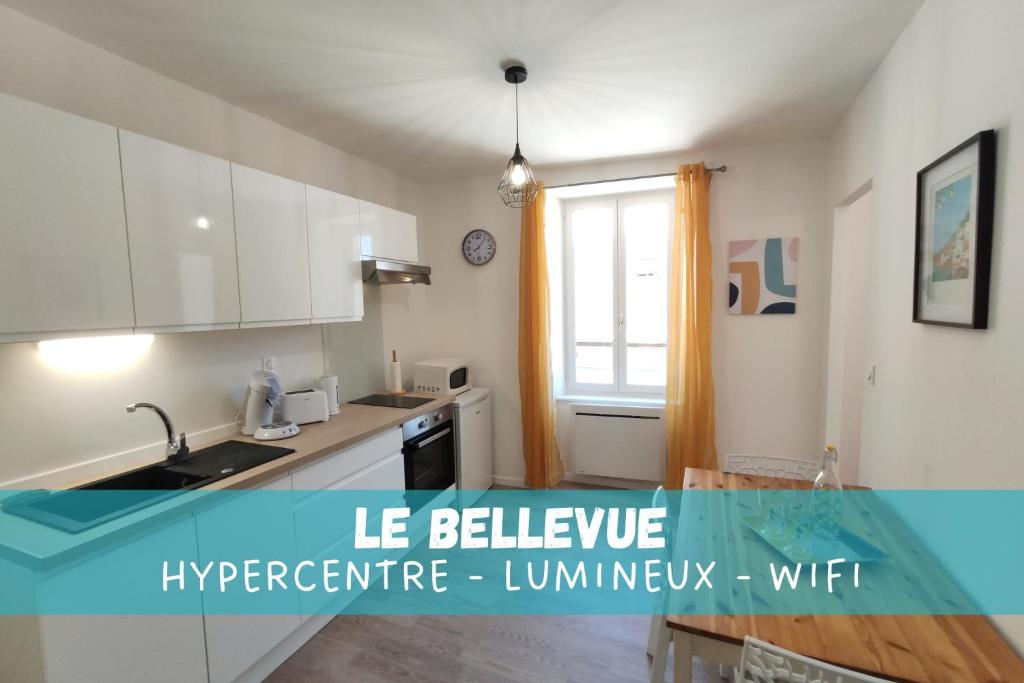 a kitchen with white cabinets and a table and a window at Le Bellevue - Focalimmo in Foix