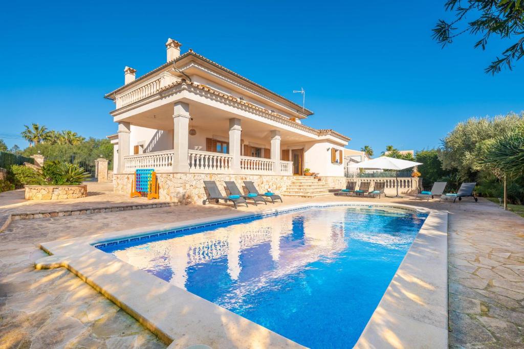 a house with a swimming pool in front of a house at Can Albons in Portocolom