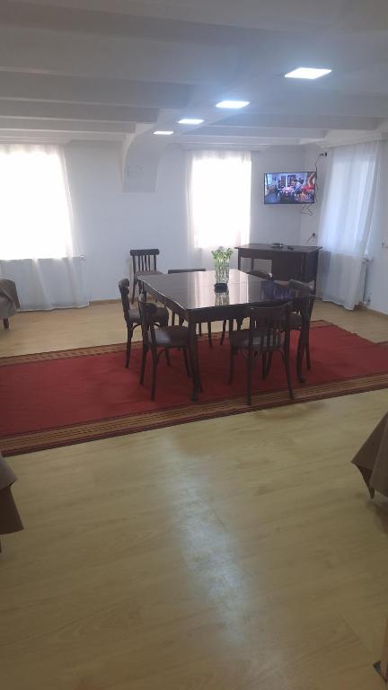 a dining room with a table and chairs and a television at Tskaltubo-house in Tsqaltubo