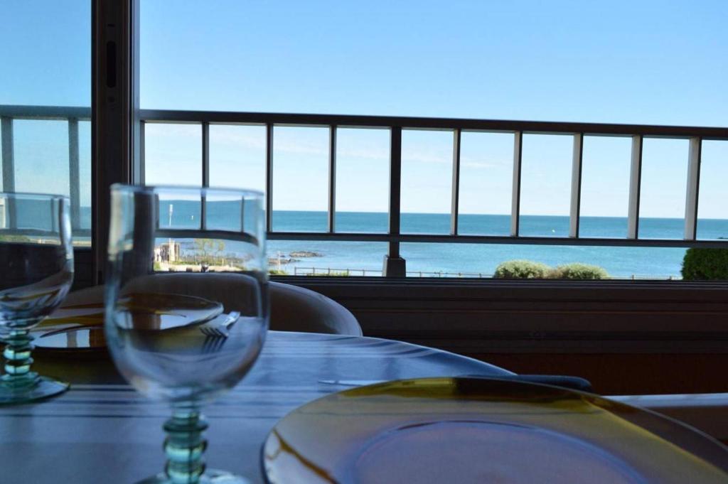 - une table avec des verres à vin et une vue sur l'océan dans l'établissement Appartement 2 pièces CAP D'AGDE CT420-121, au Cap d'Agde