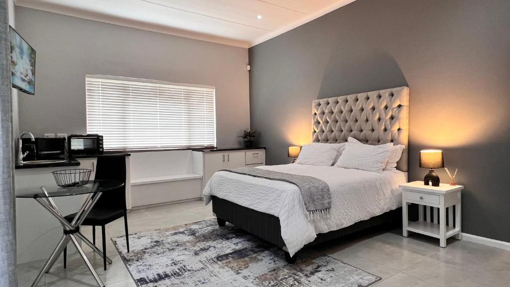 Un dormitorio con una cama, un escritorio y una mesa. en NamaStay, en Ciudad del Cabo