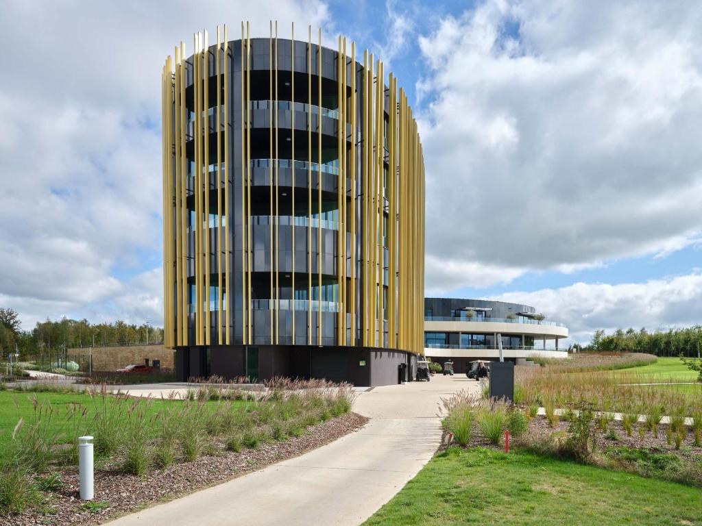 un gran edificio amarillo con una acera delante de él en Hotel du Bois d&#39;Arlon, en Arlon