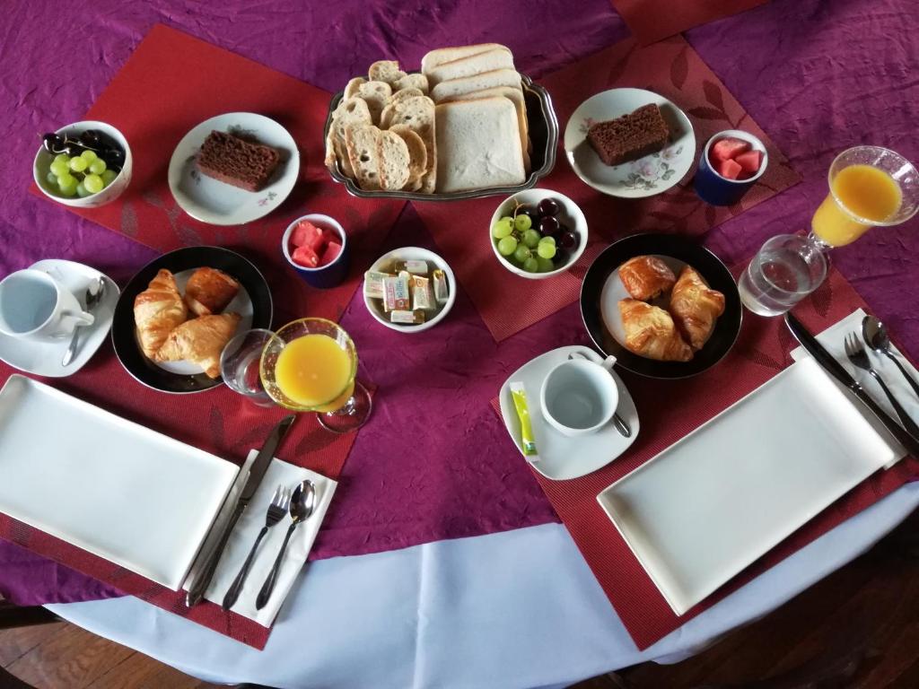 een tafel met een ontbijt van croissants en brood bij Domaine de la Ferme de Mont in Mormant
