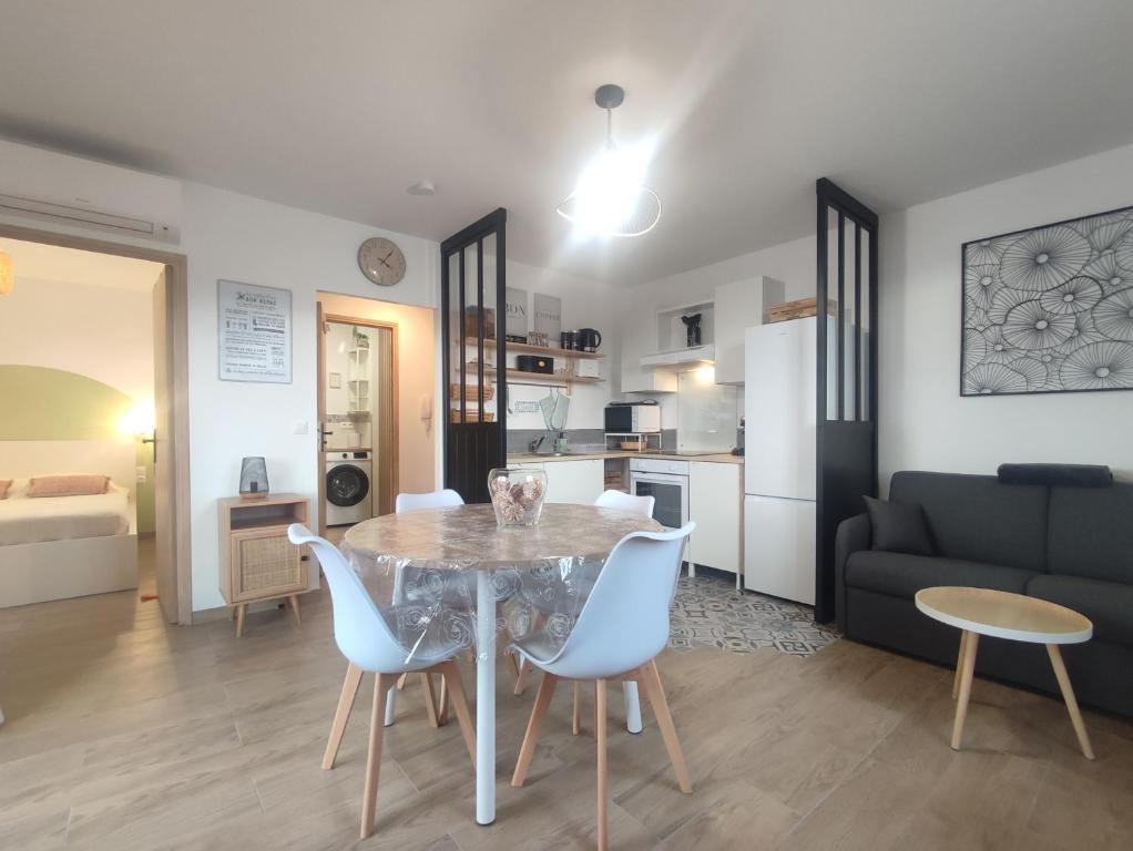 une cuisine et un salon avec une table et des chaises dans l'établissement T2 Le Bohème - climatisé, à Gréoux-les-Bains