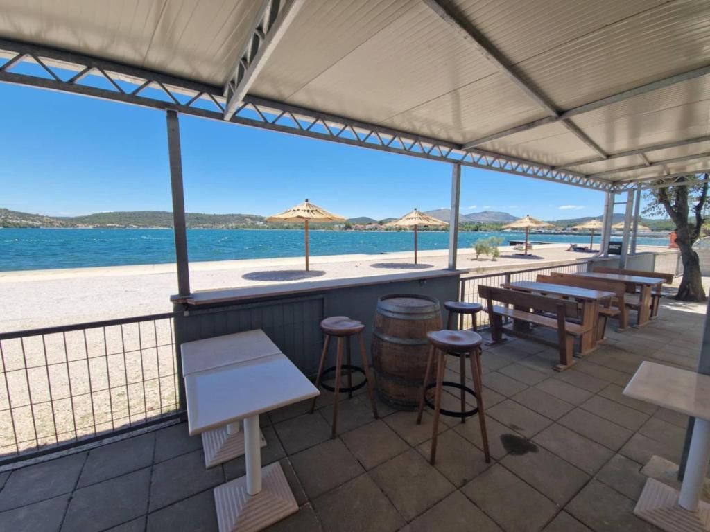 - un bar sur la plage avec des bancs et des tables dans l'établissement Apartments Oliva - Maslina, à Bilice