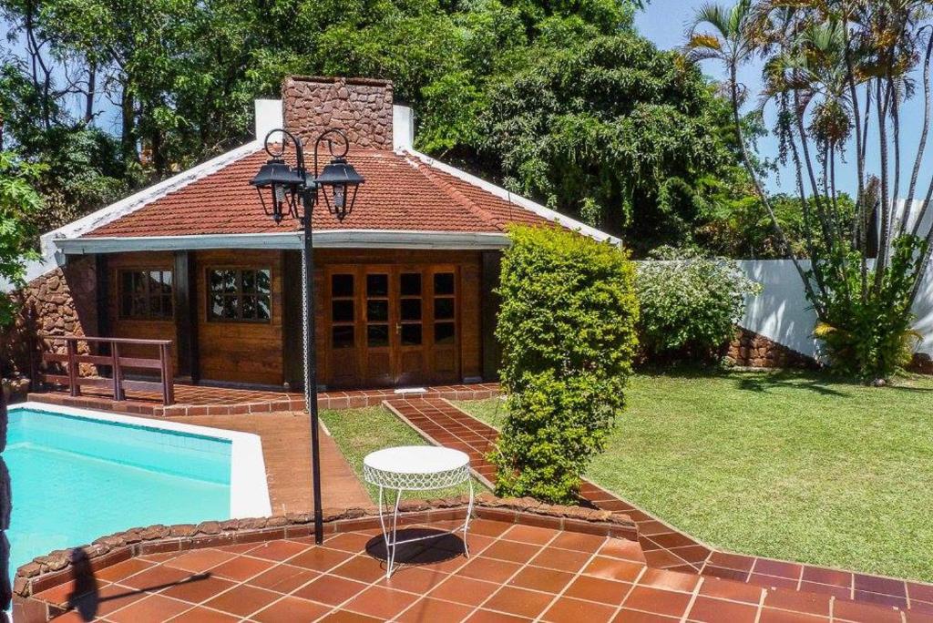 a house with a pool and a table and a lamp at Casa céntrica en Encarnación in Encarnación