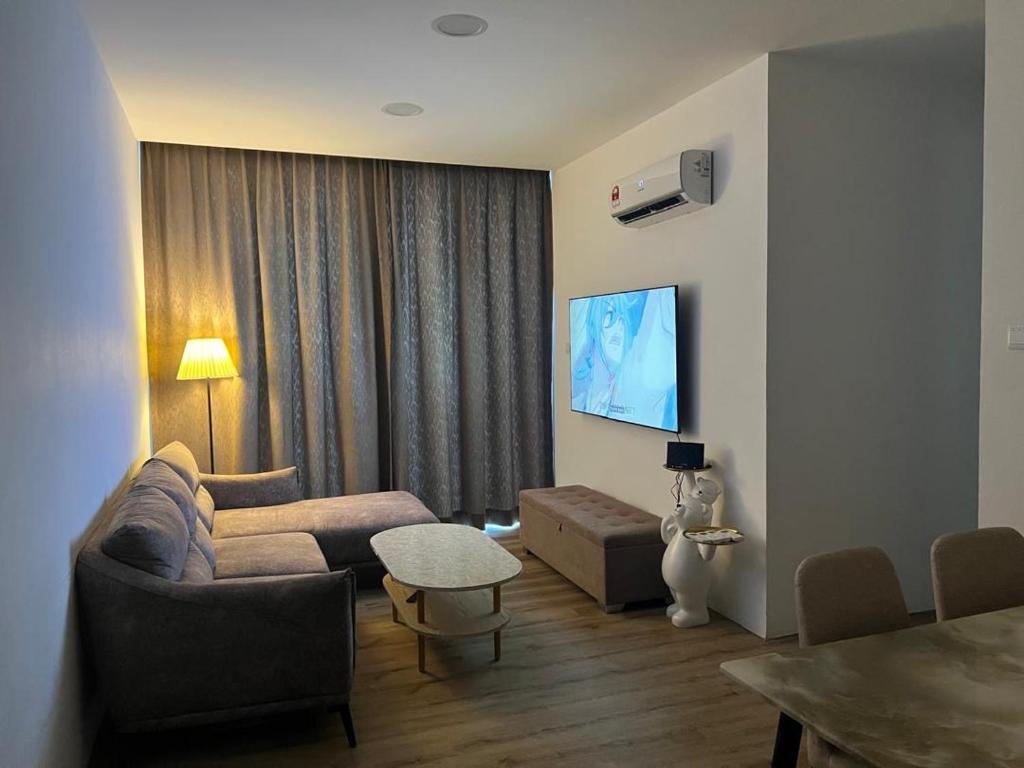 a living room with a couch and a tv at Jin Lin Homestay 1 in Sibu