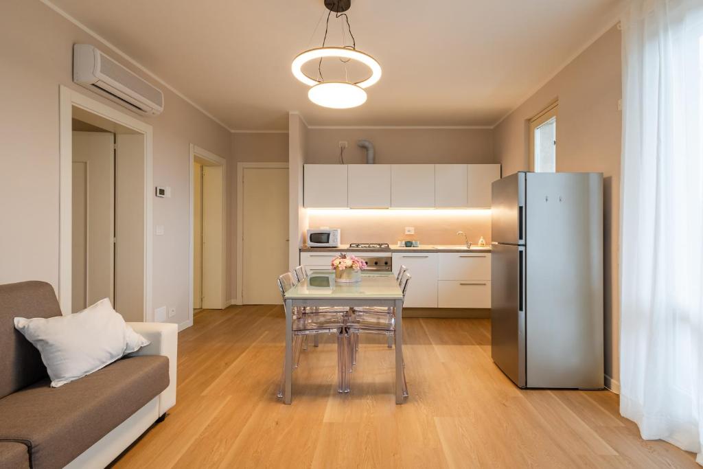 a living room with a table and a refrigerator at La Casa di Sara in Pacengo di Lazise