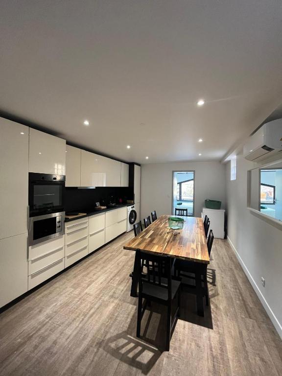 une grande cuisine avec une table et des chaises en bois dans l'établissement Chez Edouard - Superbe Triplex neuf - 6 chambres - Centre ville proche Rotonde allées provençales, à Aix-en-Provence