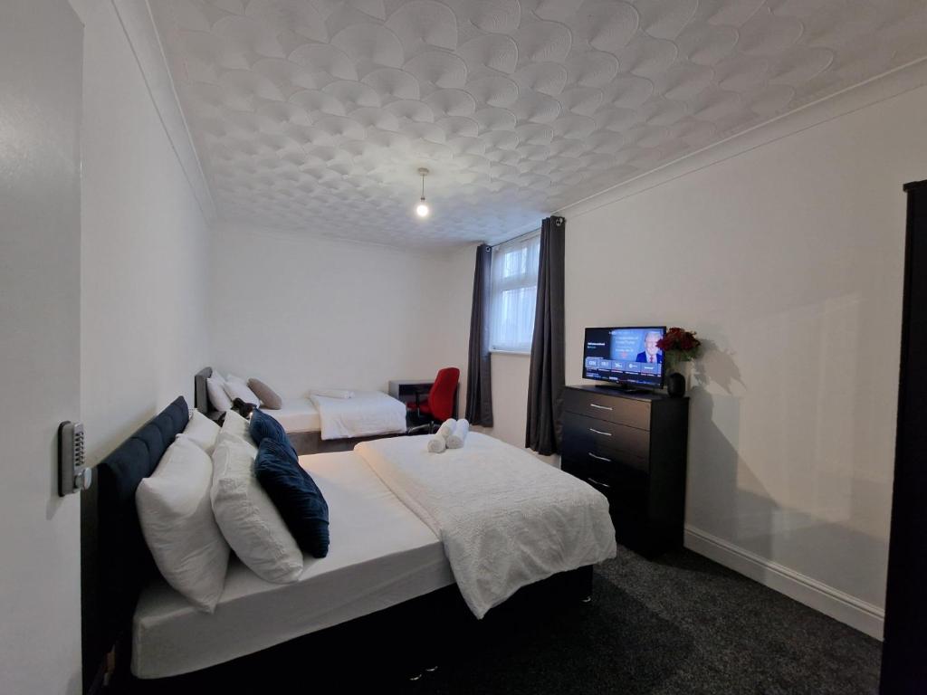 a bedroom with a bed and a flat screen tv at Nice Living Serviced Accommodations Leicester in Leicester