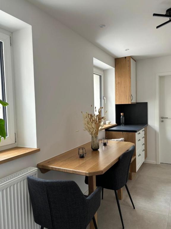 a kitchen with a wooden table and two chairs at Moderne 2-Schlafzimmer Wohnung für 2-3 Personen - Optimal für Arbeit und Erholung in Markt Indersdorf