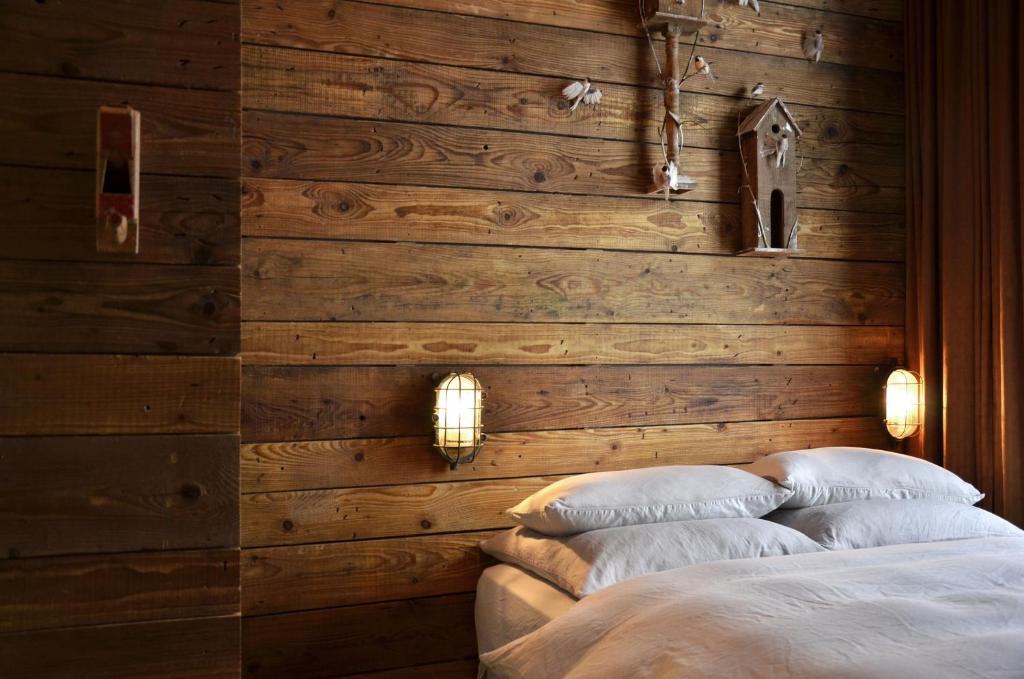 ein Schlafzimmer mit einer Holzwand mit zwei Kissen auf einem Bett in der Unterkunft Linnen in Berlin