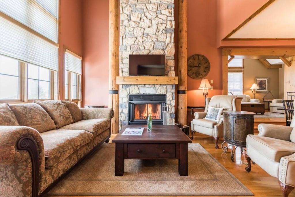 Una sala de estar con un sofá y una chimenea. en Luxury Mountain Escape- Equinoxe 140-1, en Mont-Tremblant