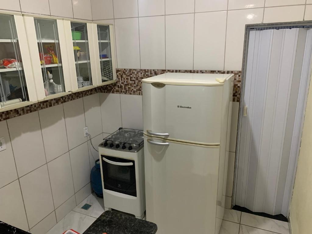 eine kleine Küche mit einem Kühlschrank und einem Herd in der Unterkunft Casa para temporada- Pq Mambucaba in Angra dos Reis