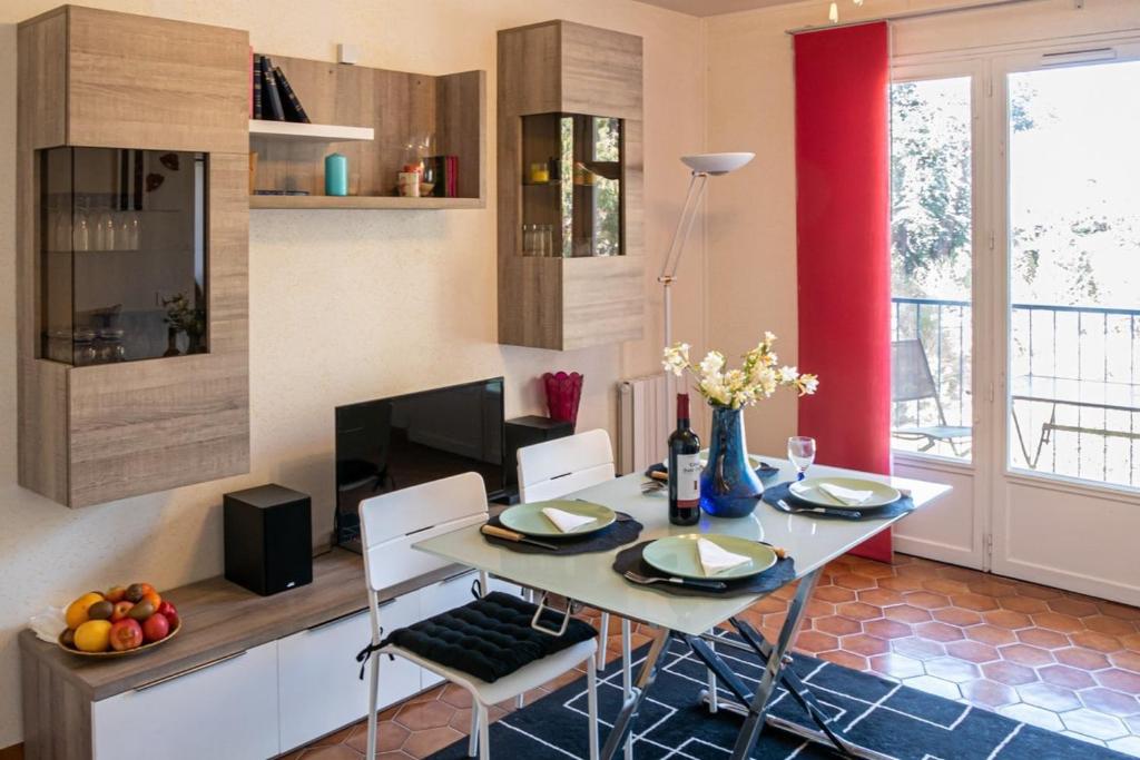 une salle à manger avec une table et des chaises dans une cuisine dans l'établissement T2 Bormes les Mimosas - La Favière, à Bormes-les-Mimosas