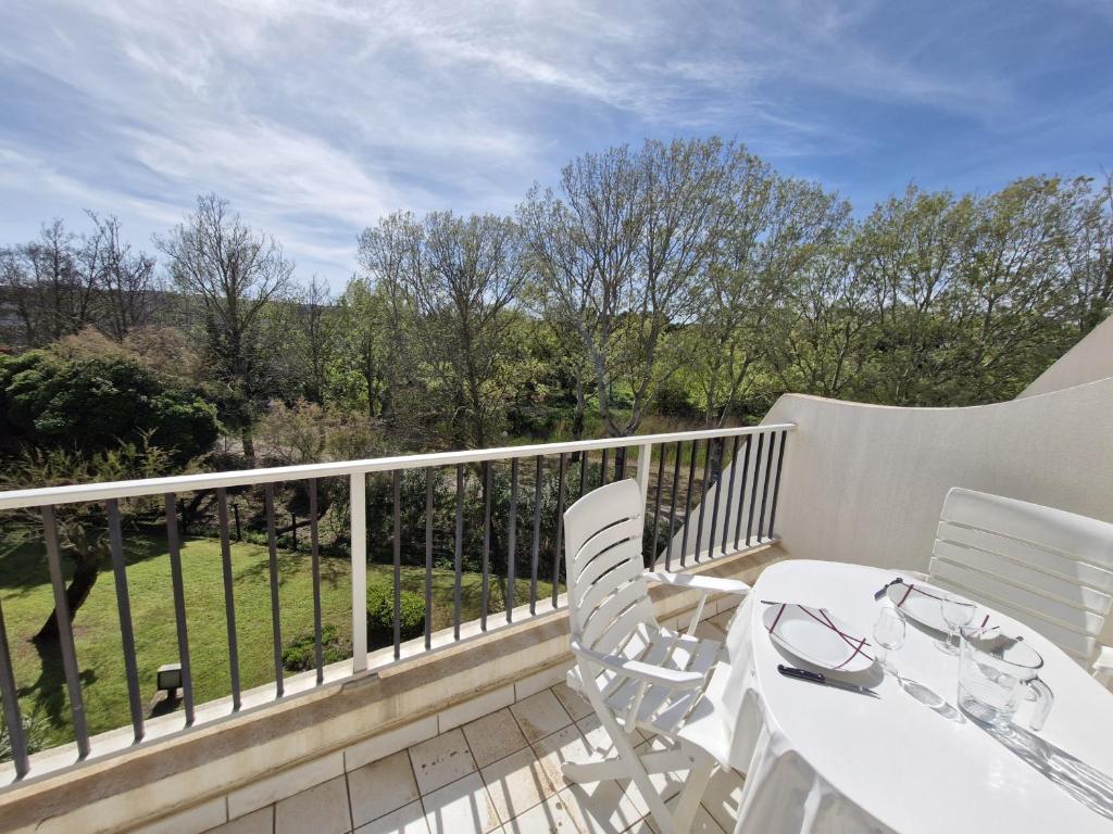 un balcon avec une table et des chaises et une vue dans l'établissement Sol-y-Days Hermes, grande terrasse au calme 5 mn des plages, à La Grande Motte