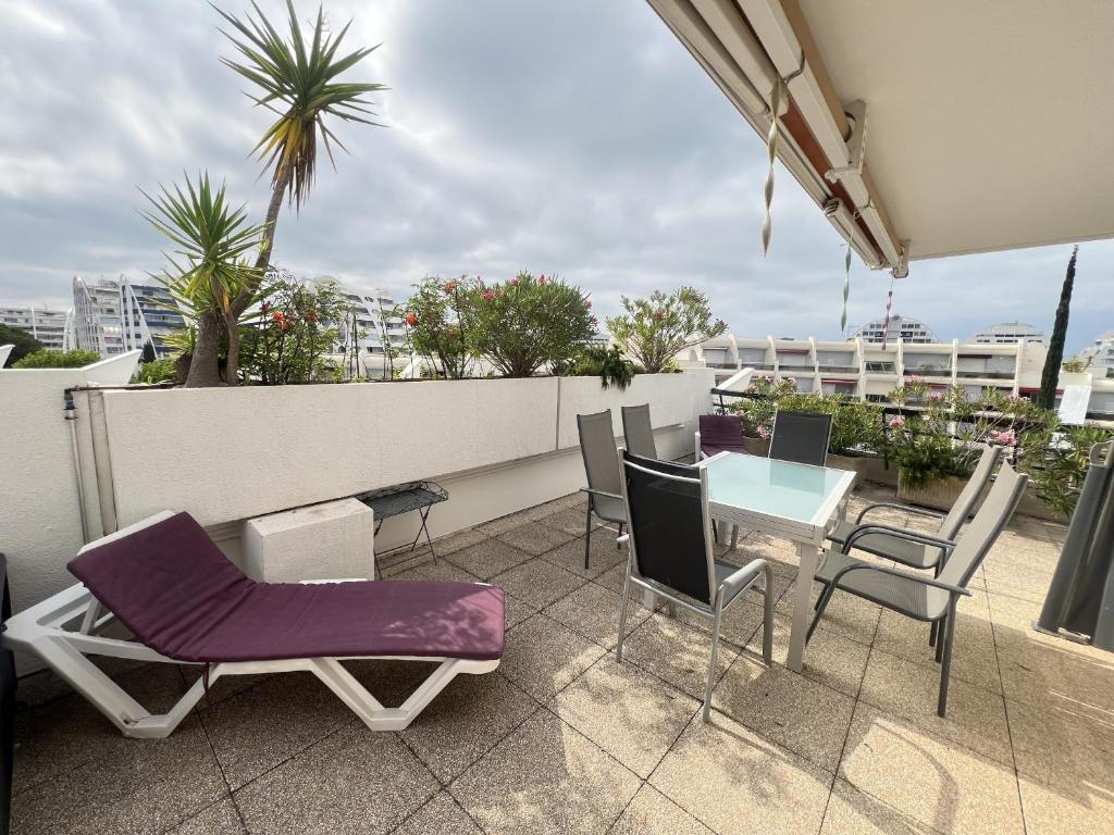 un patio avec des chaises et une table sur un balcon dans l'établissement Sol-y-Days Flamants roses, grande terrasse et piscine, à La Grande Motte