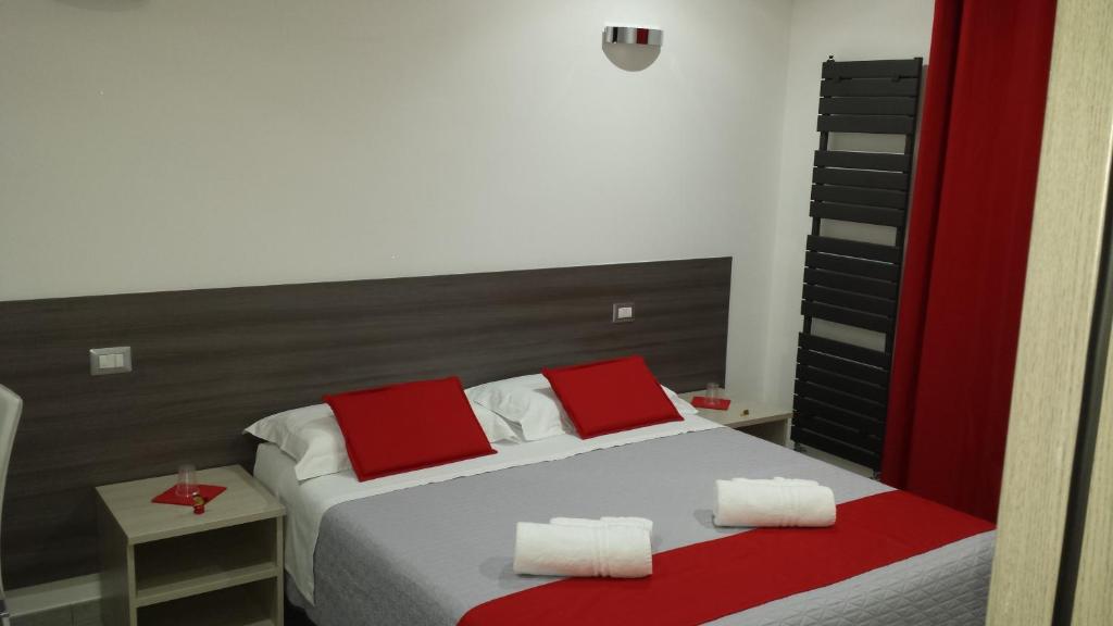 1 dormitorio con 1 cama con almohadas rojas y blancas en La Maison de Monet, en Brindisi