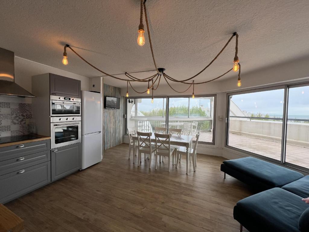 une cuisine et une salle à manger avec une table et des chaises dans l'établissement Sol-y-Days Ulysse Plages, terrasse panoramique avec vue sur mer, à La Grande Motte