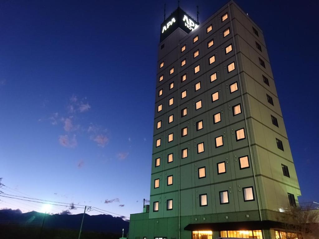 a tall building with a clock on top of it at APA Hotel Kofu Minami in Kofu
