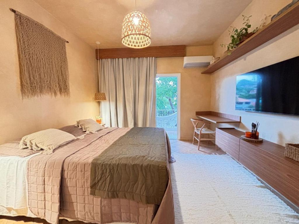 a bedroom with a bed and a desk and a television at Apartamento Morro de São Paulo Centro - Mirar in Morro de São Paulo