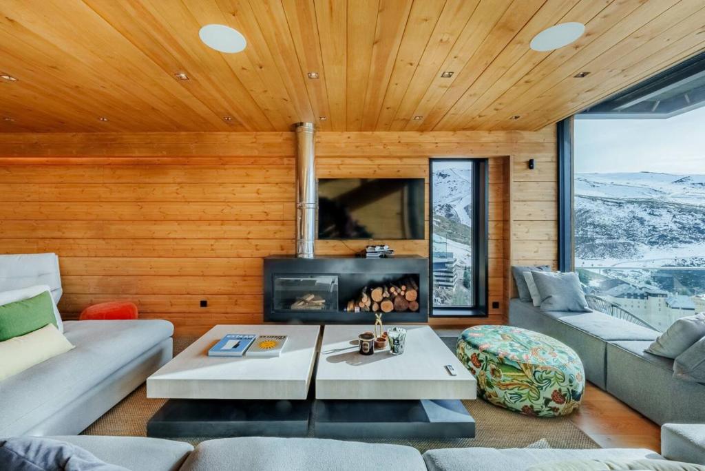 Una sala de estar con un sofá y una chimenea. en Luxury Chalet in Sierra Nevada with Views, en Sierra Nevada