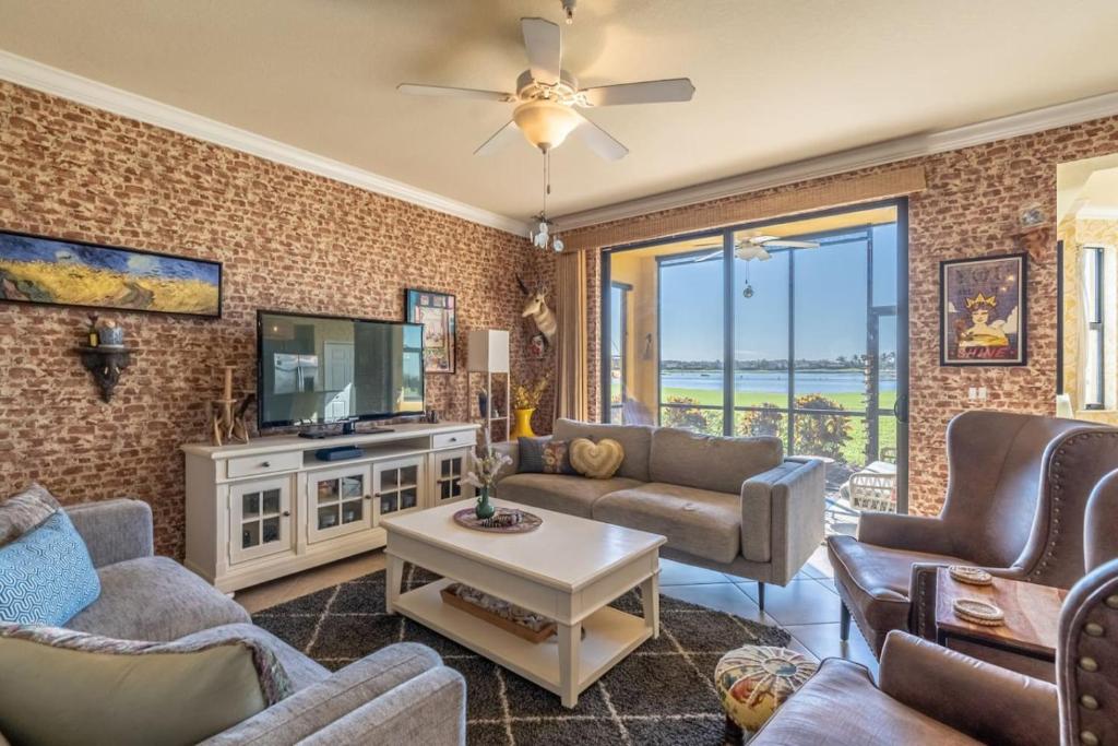 a living room with a couch and a tv at Live in Paradise with Golf Tennis Gym Pools and More! in Bonita Springs
