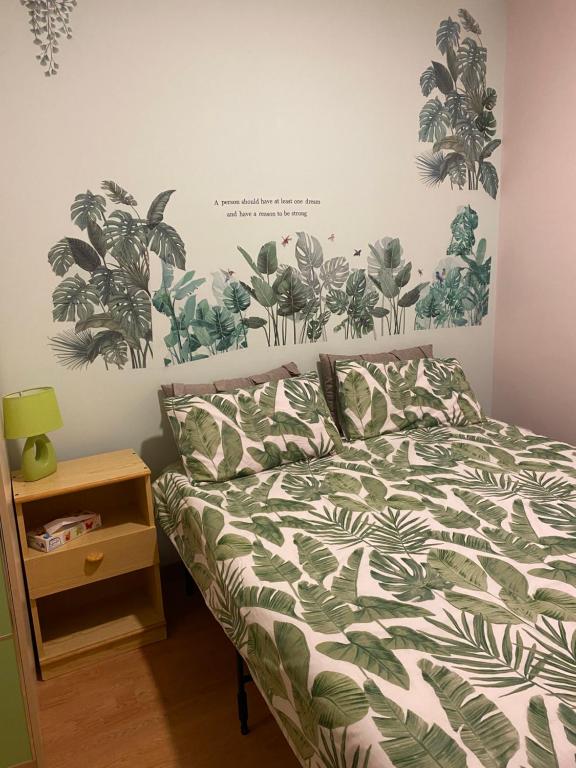 a bedroom with a bed with green and white comforter at B&B Il Faraglione Bianco in Vieste