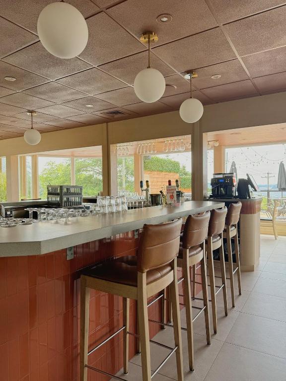 a bar with a row of bar stools at Auberge le Parasol in Saguenay