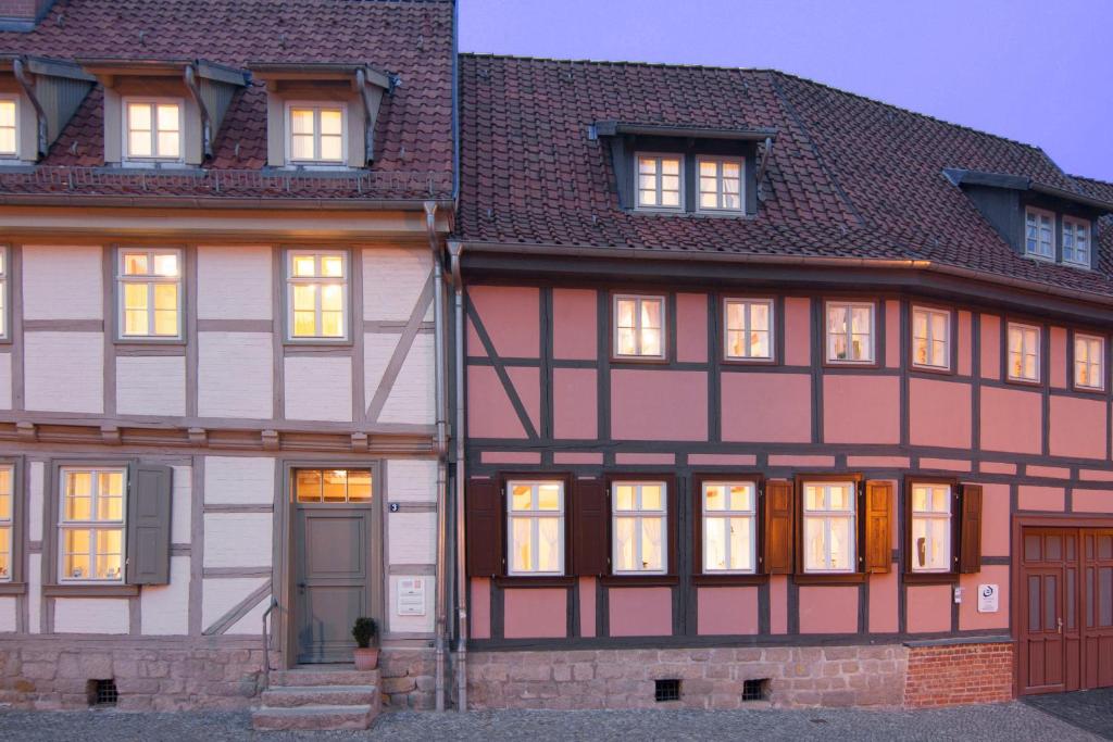 zwei ältere Häuser mit eingeschaltetem Licht in der Unterkunft Urlaub im Fachwerk - Klink in Quedlinburg