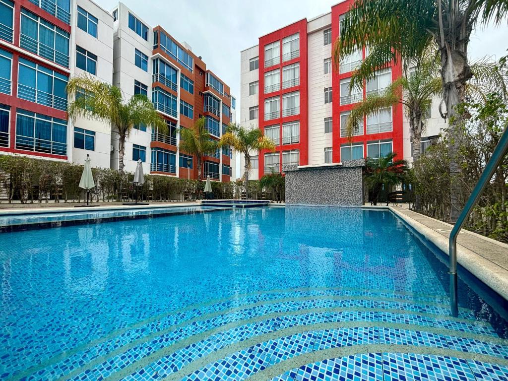 a large blue swimming pool with buildings in the background at Las Casitas - Milina in Salinas