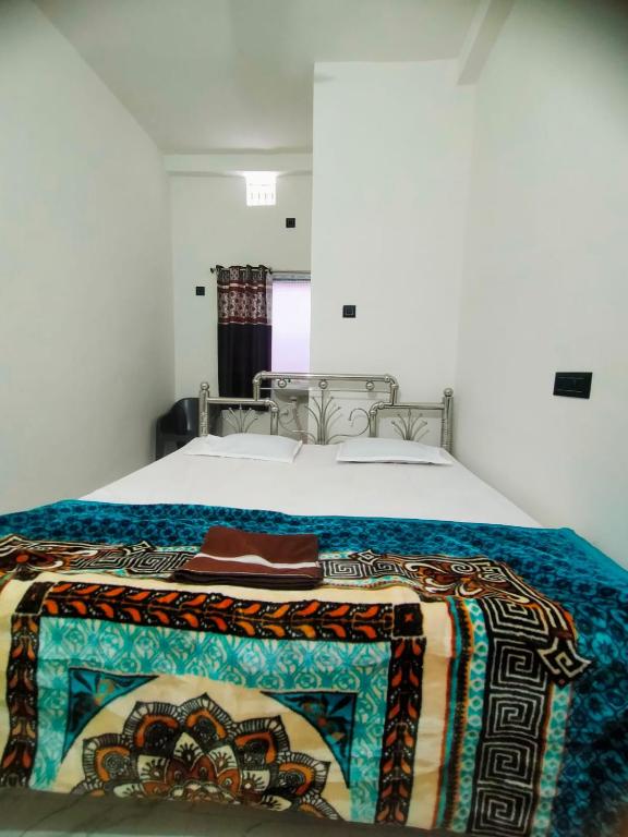 a bed with a blanket on top of it at Shivay Guest house in Jasidih