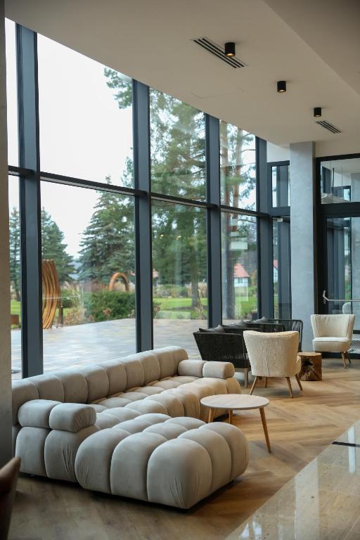 duży salon z dużą kanapą i krzesłami w obiekcie Hotel Mazurski Raj w mieście Ruciane-Nida