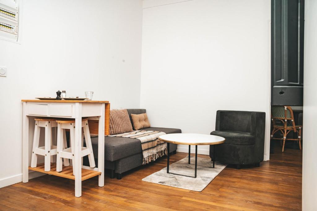 un salon avec un canapé et une table dans l'établissement Hostel Bords de Marne 1, à Gournay-sur-Marne
