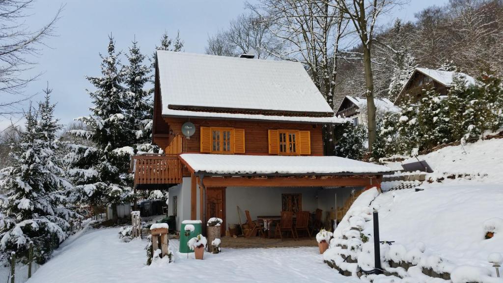 a wooden house with snow on the roof at Ferienhaus Sonnenblick Entspannung mit Sauna Kamin und Balkon in Sonneberg