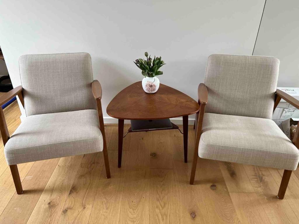 two chairs and a wooden table with a vase on it at Cozy little house in Aalborg