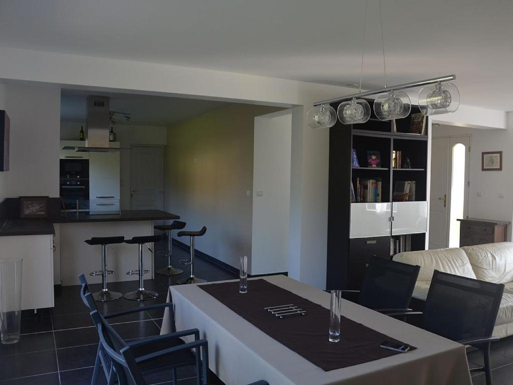 a kitchen and a living room with a table and chairs at Maison Reine-Claude in Esbly