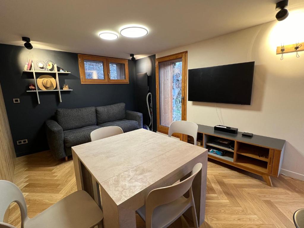 un salon avec une table et un canapé dans l'établissement Appartement AOKI C, à Valloire