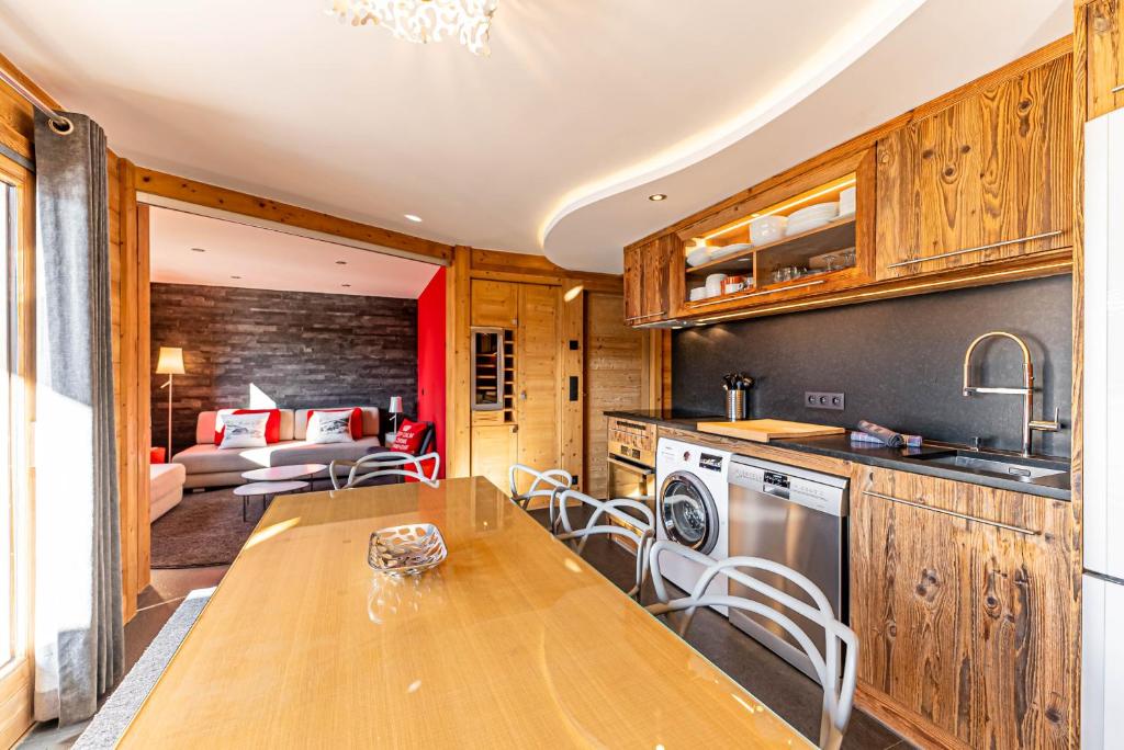 une cuisine avec une table et un salon dans l'établissement Appartement Sandflake - LES GETS, proche du centre et des pistes, aux Gets