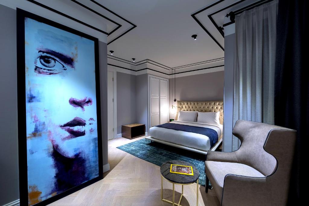 a bedroom with a bed and a large painting at Walton Hotels Galata in Istanbul
