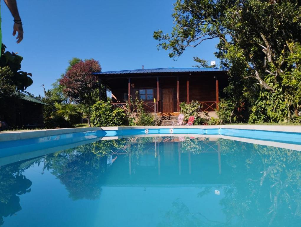 a house with a swimming pool in front of a house at Casa de la Guayubira in El Soberbio